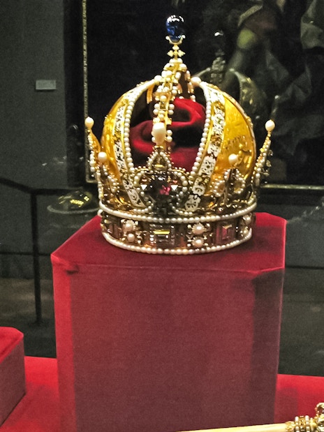Crown jewels displayed at the Tower of London, featuring an ornate crown and scepter.
