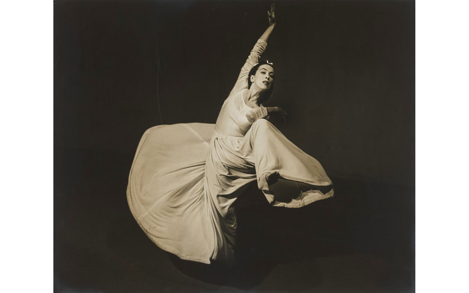 Dancer in flowing dress performing at National Gallery of Victoria's "A Legacy of Light" exhibit.