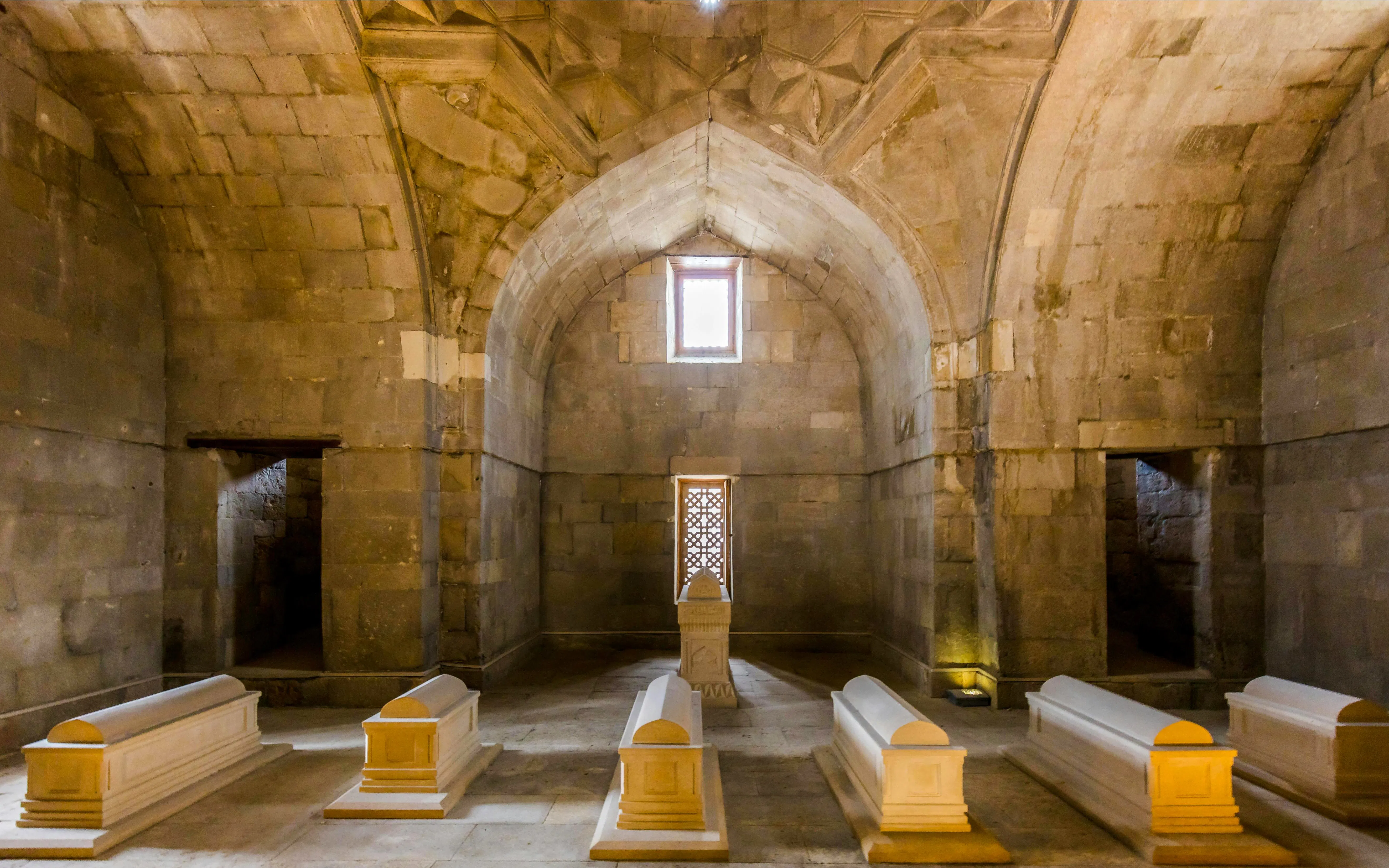 Tombs inside the Palace of Shirvanshahs, Baku, showcasing intricate stone architecture.
