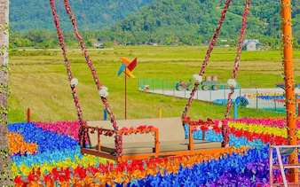 Colorful swing surrounded by vibrant pinwheels at De Windmill Selfie Park.