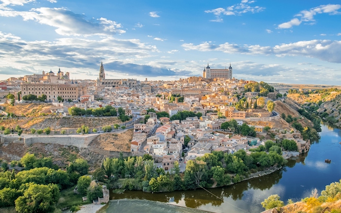 Toledo cityscape with Alcázar and Tagus River.