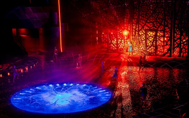 Performers on illuminated water stage at La Perle show, Dubai.