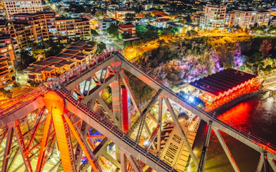 Climbers on Story Bridge at night with city lights in Brisbane, Australia.