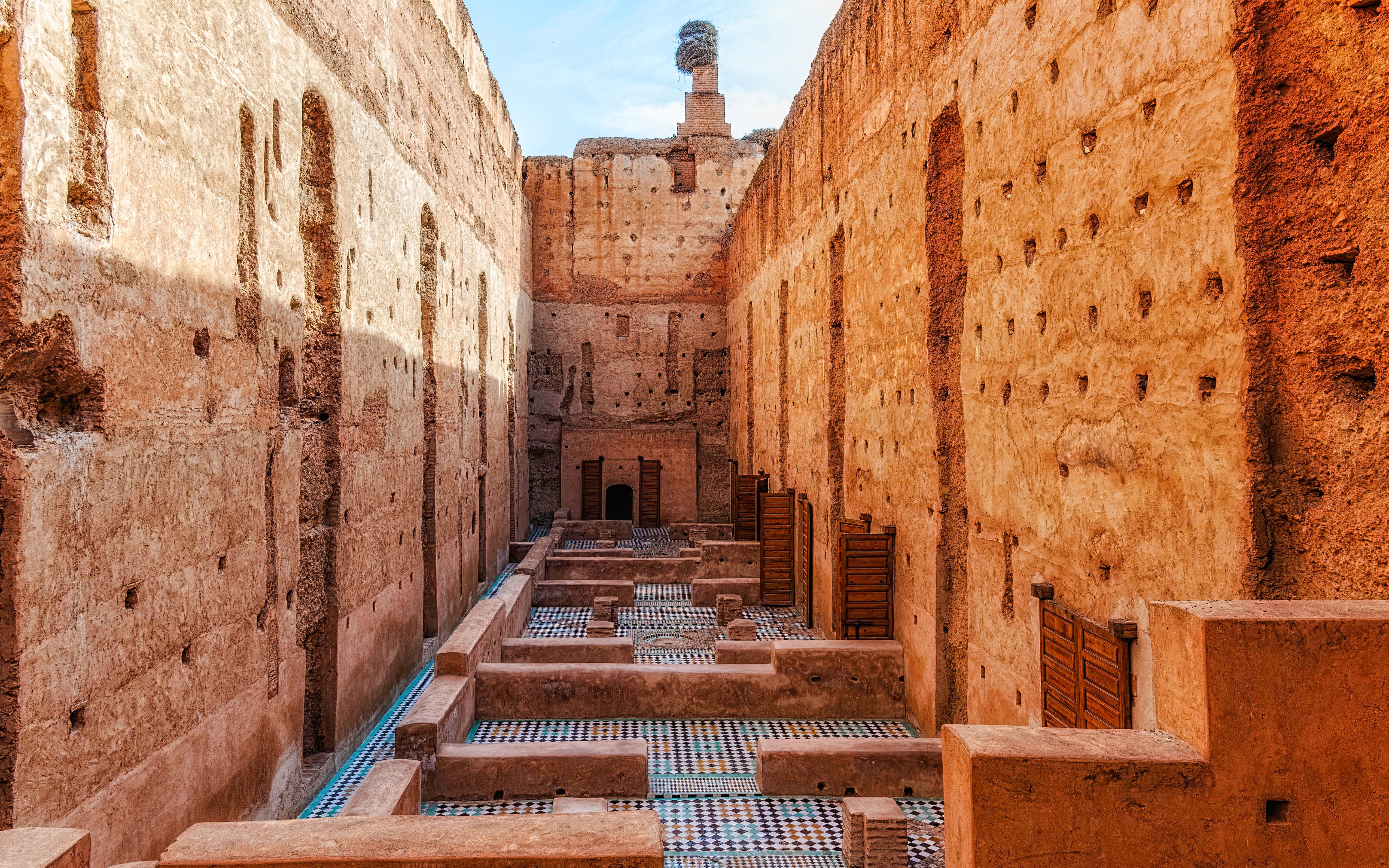 Courtyard ruins of El Badi Palace with mosaic floors and high walls in Marrakech, Morocco.