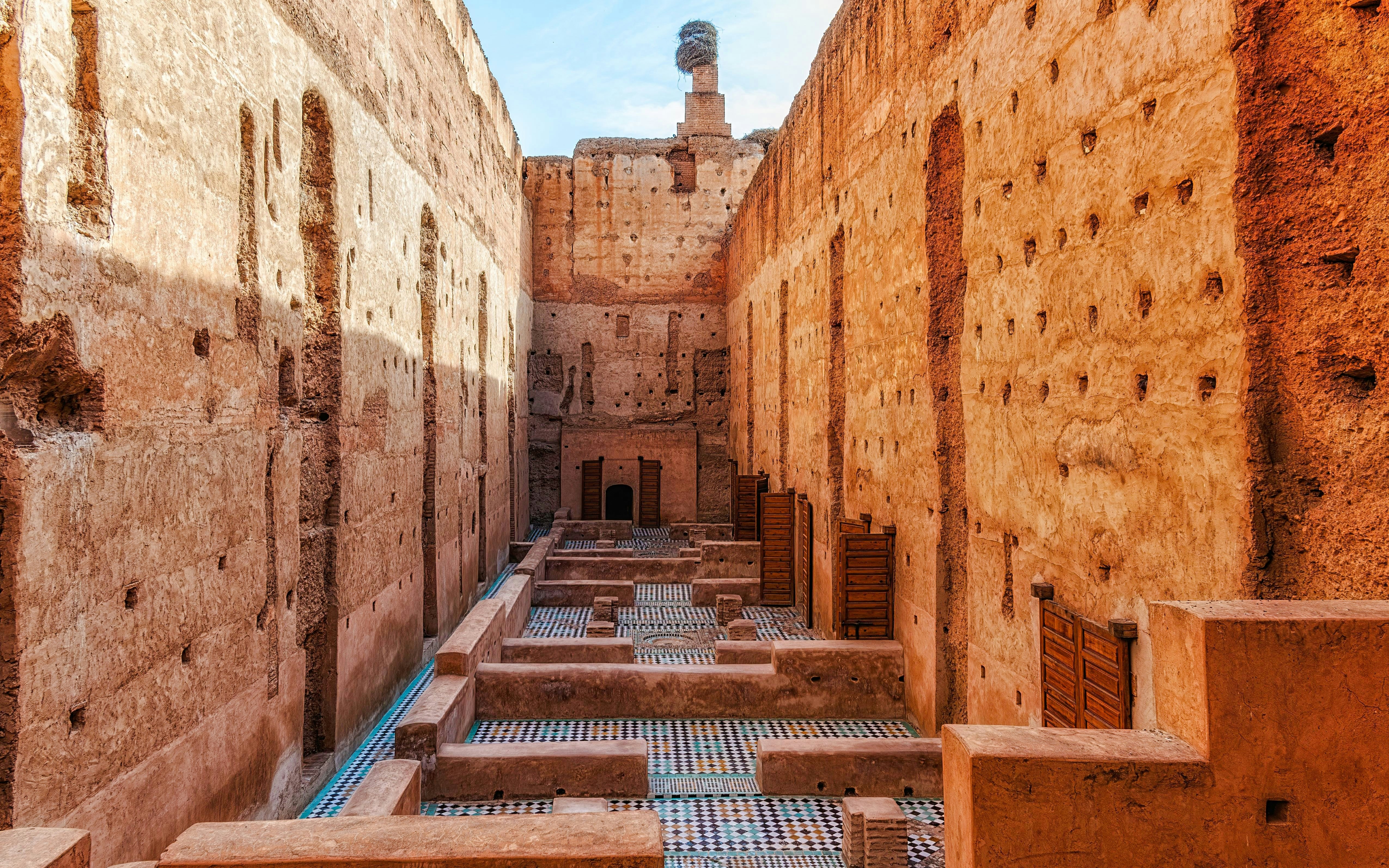 Courtyard ruins of El Badi Palace with mosaic floors and high walls in Marrakech, Morocco.