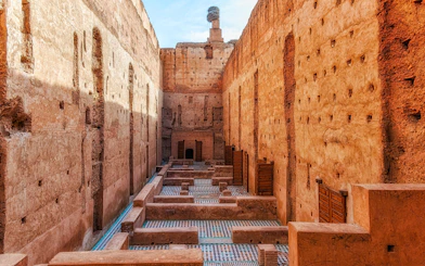 Courtyard ruins of El Badi Palace with mosaic floors and high walls in Marrakech, Morocco.