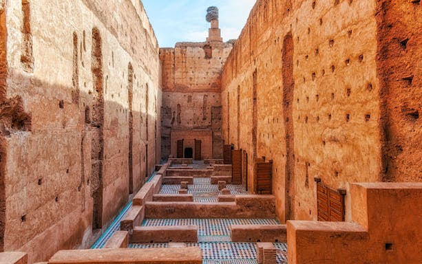 Courtyard ruins of El Badi Palace with mosaic floors and high walls in Marrakech, Morocco.
