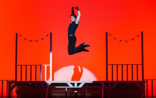 Performer leaping on stage during Dirty Dancing show.