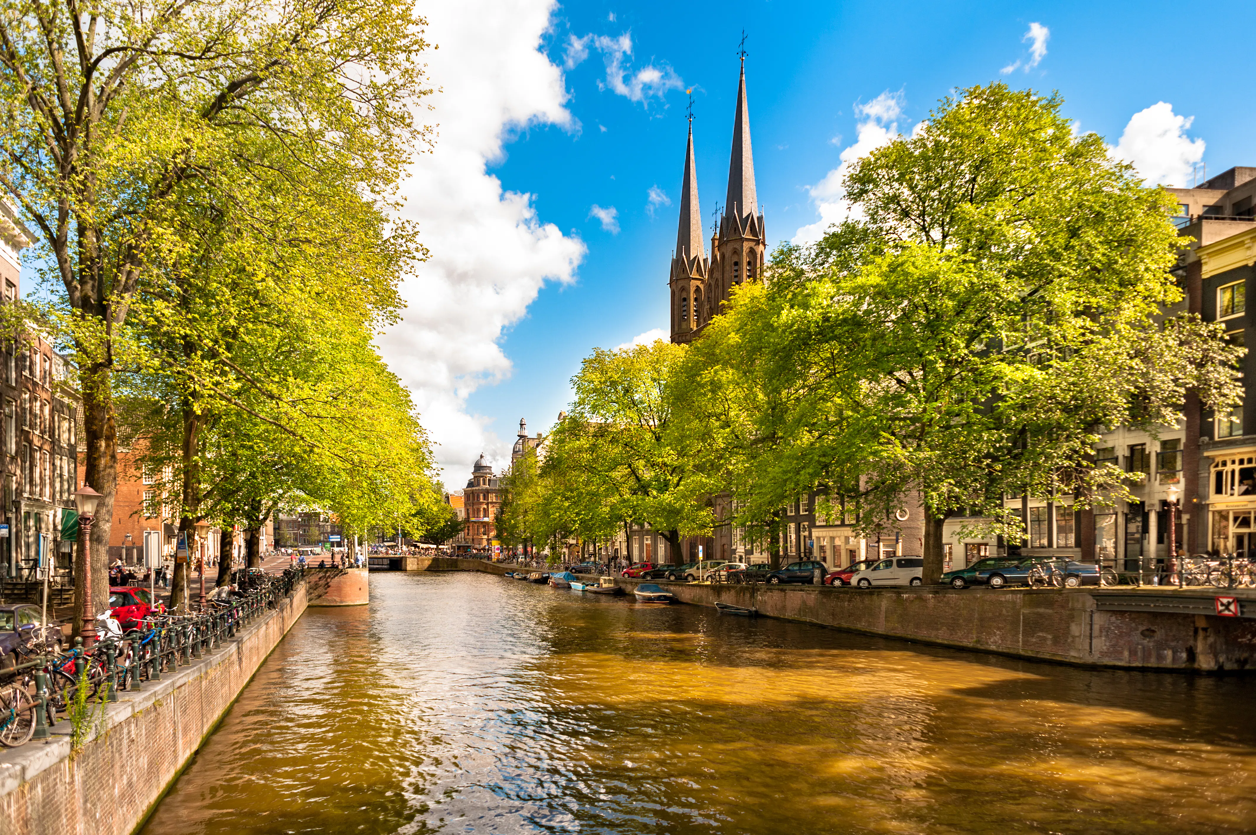 Singel Canal in Amsterdam with Bartolotti House and church spires in the background.