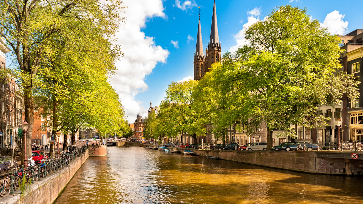 Singel Canal in Amsterdam with Bartolotti House and church spires in the background.
