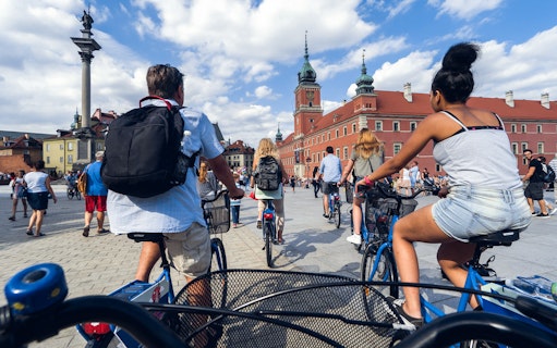 Cyclists on a tour in Warsaw's Old Town near Sigismund's Column.