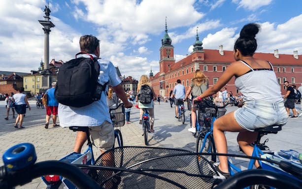 Cyclists on a tour in Warsaw's Old Town near Sigismund's Column.