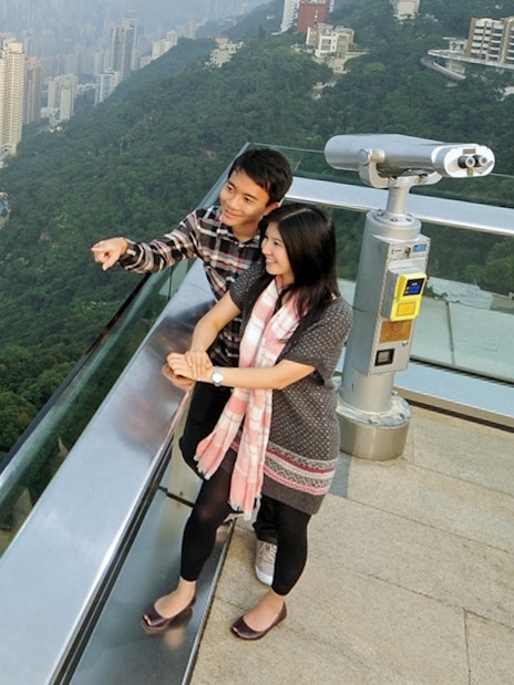 Couple enjoying Hong Kong skyline view from Sky Terrace 428 at The Peak.