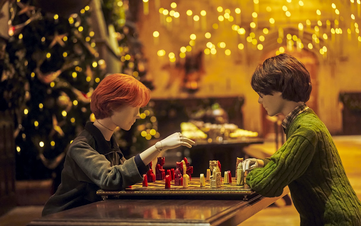 Mannequins playing wizard chess in the Great Hall, Christmas setting, Harry Potter Studio Tour Tokyo.