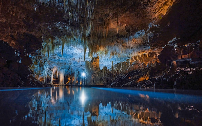 Illuminated stalactites and reflections in Lake Cave, Margaret River.