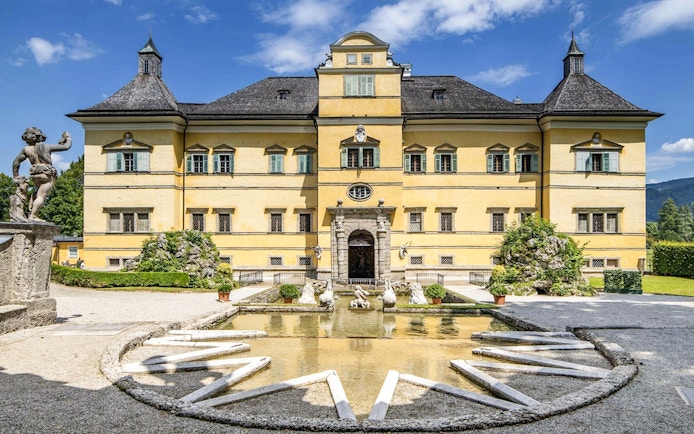 Hellbrunn Palace exterior with fountain and statues in Salzburg, Austria.