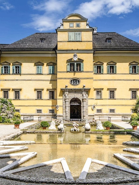 Hellbrunn Palace exterior with fountain and statues in Salzburg, Austria.