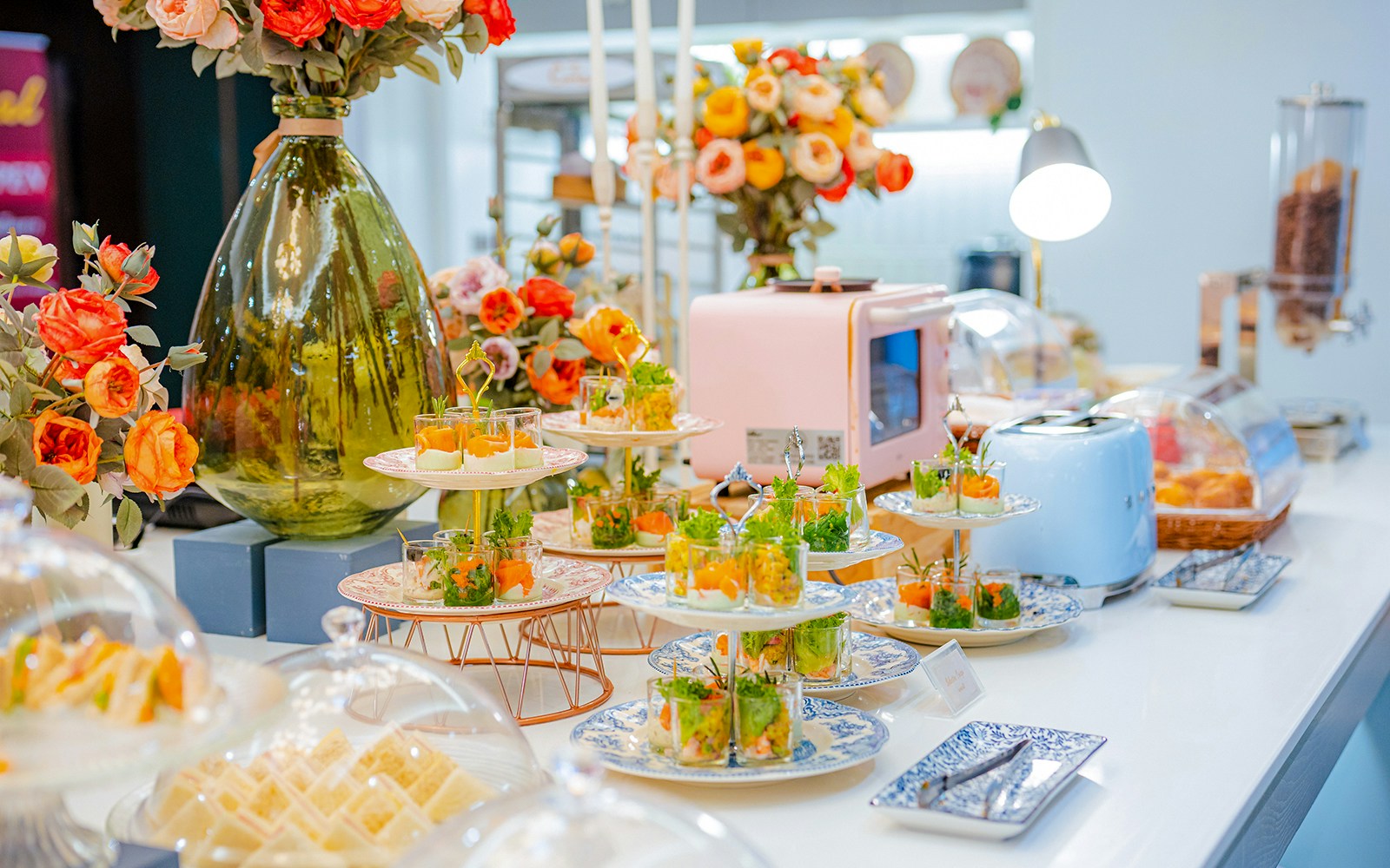 Buffet spread with appetizers and flowers at Coral Finest Business Class Lounge, Bangkok airport.
