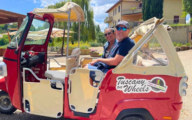 Vintage Tuk Tuk with driver and passenger on San Gimignano scenic tour, Tuscany.