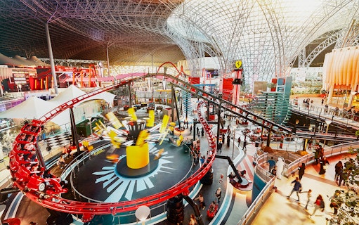 Ferrari World Abu Dhabi indoor roller coaster with visitors exploring attractions.