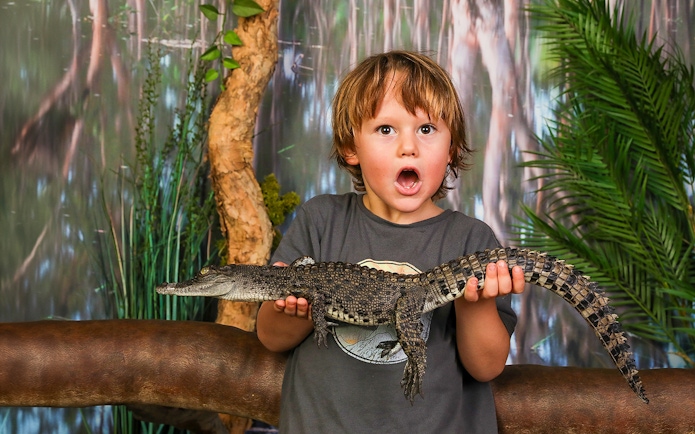 Child holding a baby crocodile at Crocosaurus Cove, Darwin.