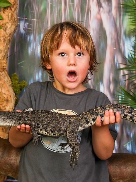 Child holding a baby crocodile at Crocosaurus Cove, Darwin.