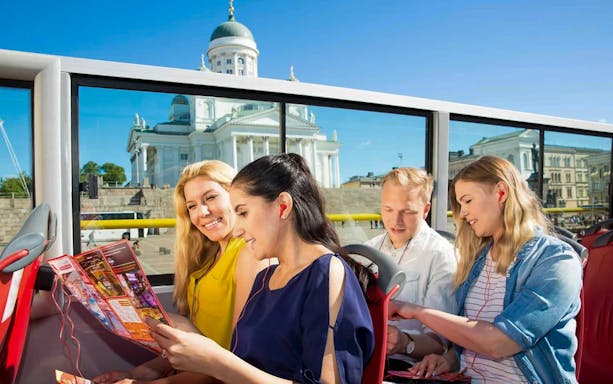 Guests on Helsinki Hop-on Hop-off Bus Tour with Helsinki Cathedral in background.