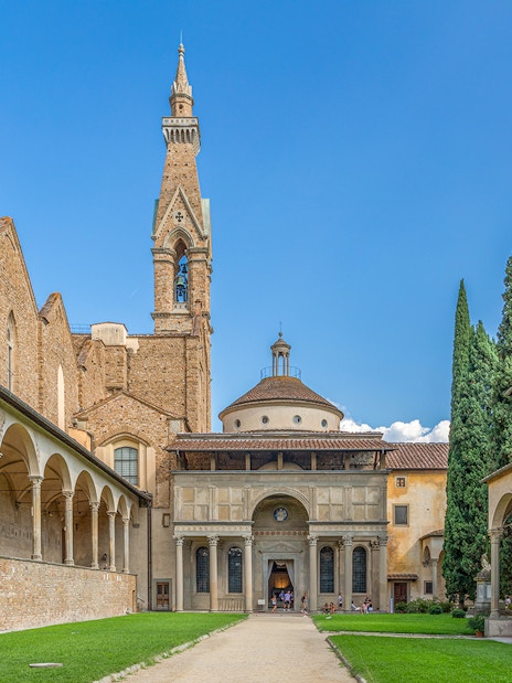 Santa Croce courtyard in Florence with bell tower and arches.