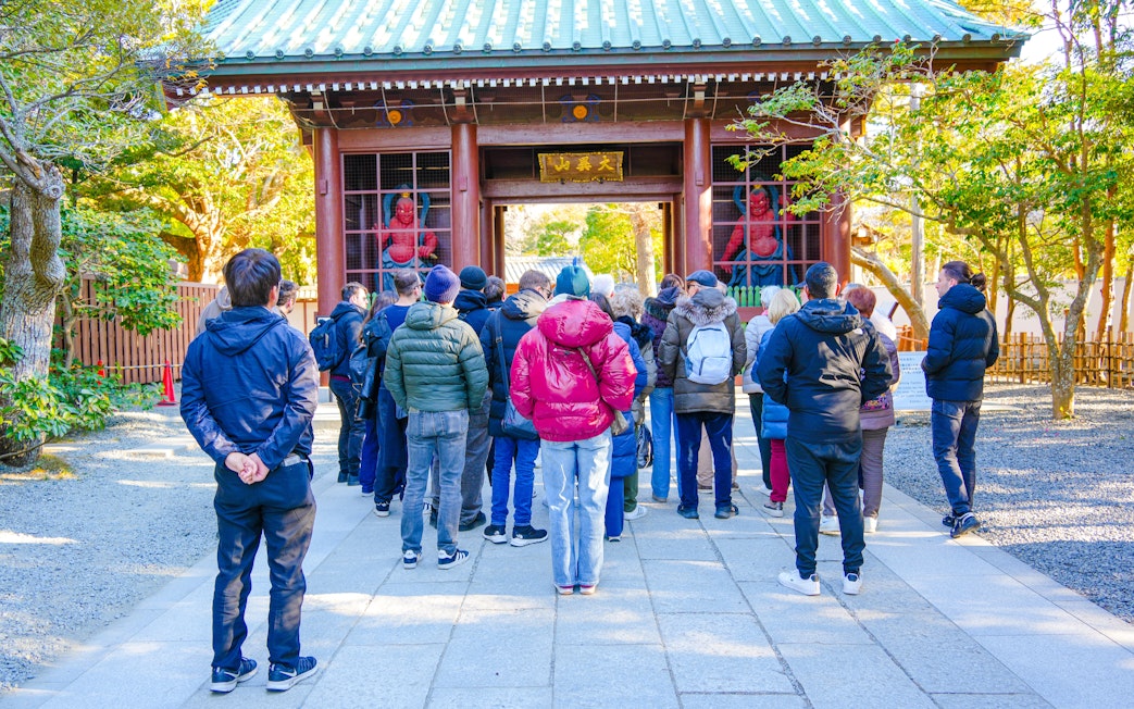 Tour group at a temple entrance in Japan during Mount Fuji, Lake Ashi & Big Buddha day tour.