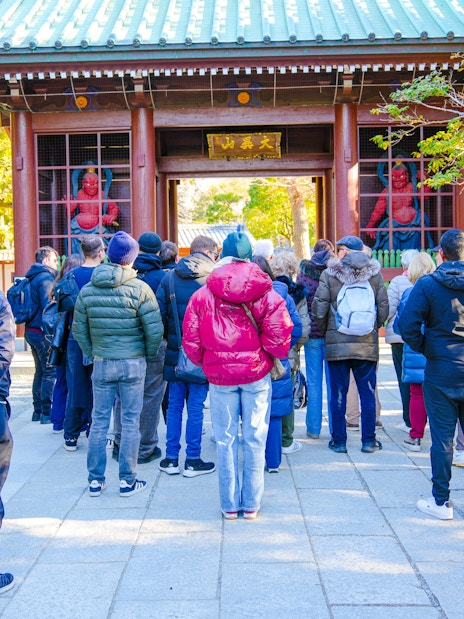 Tour group at a temple entrance in Japan during Mount Fuji, Lake Ashi & Big Buddha day tour.