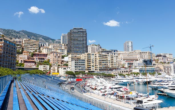 Monaco harbor with yachts and grandstands along the Formula 1 circuit.