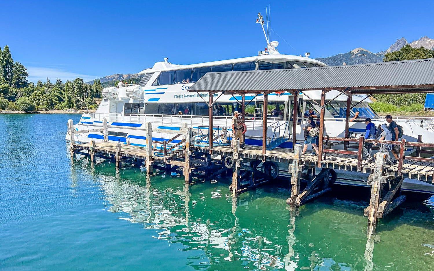 Dock at Puerto Blest with tourists boarding a boat on Nahuel Huapi Lake, Argentina.