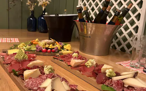 Charcuterie board with meats and cheeses, wine bottles in a bucket, Paris Le Marais food tour.