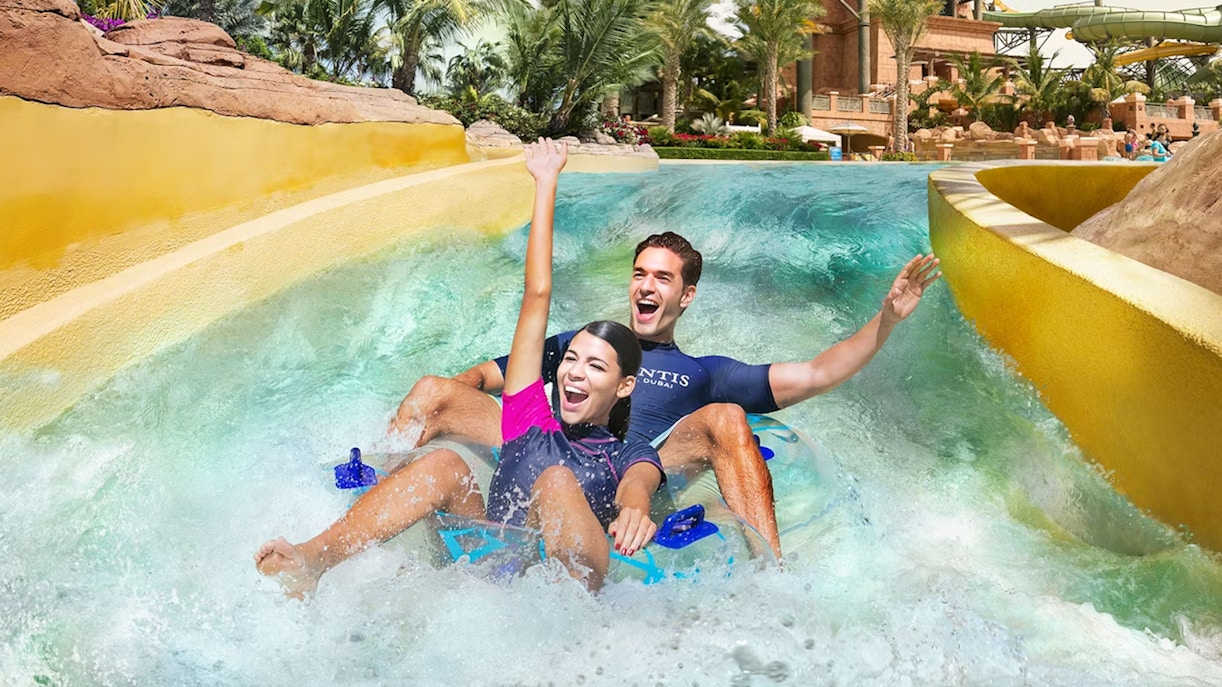 Tourists enjoying thrilling water slides at Aquaventure Waterpark, part of the Aquaventure and The Lost Chambers Aquarium Combo Tickets in Dubai