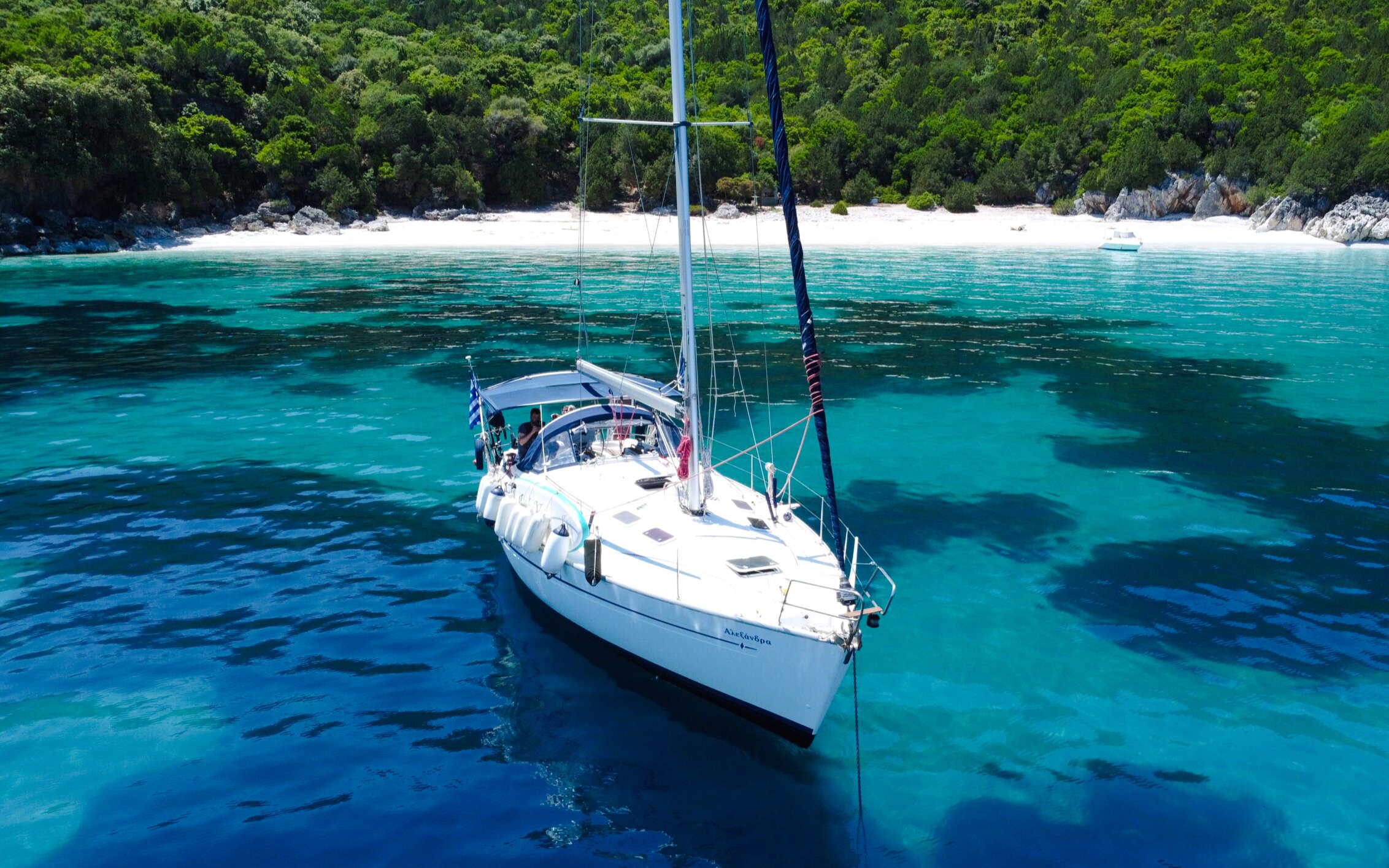 Sailing yacht on turquoise waters near a secluded beach in Kefalonia.