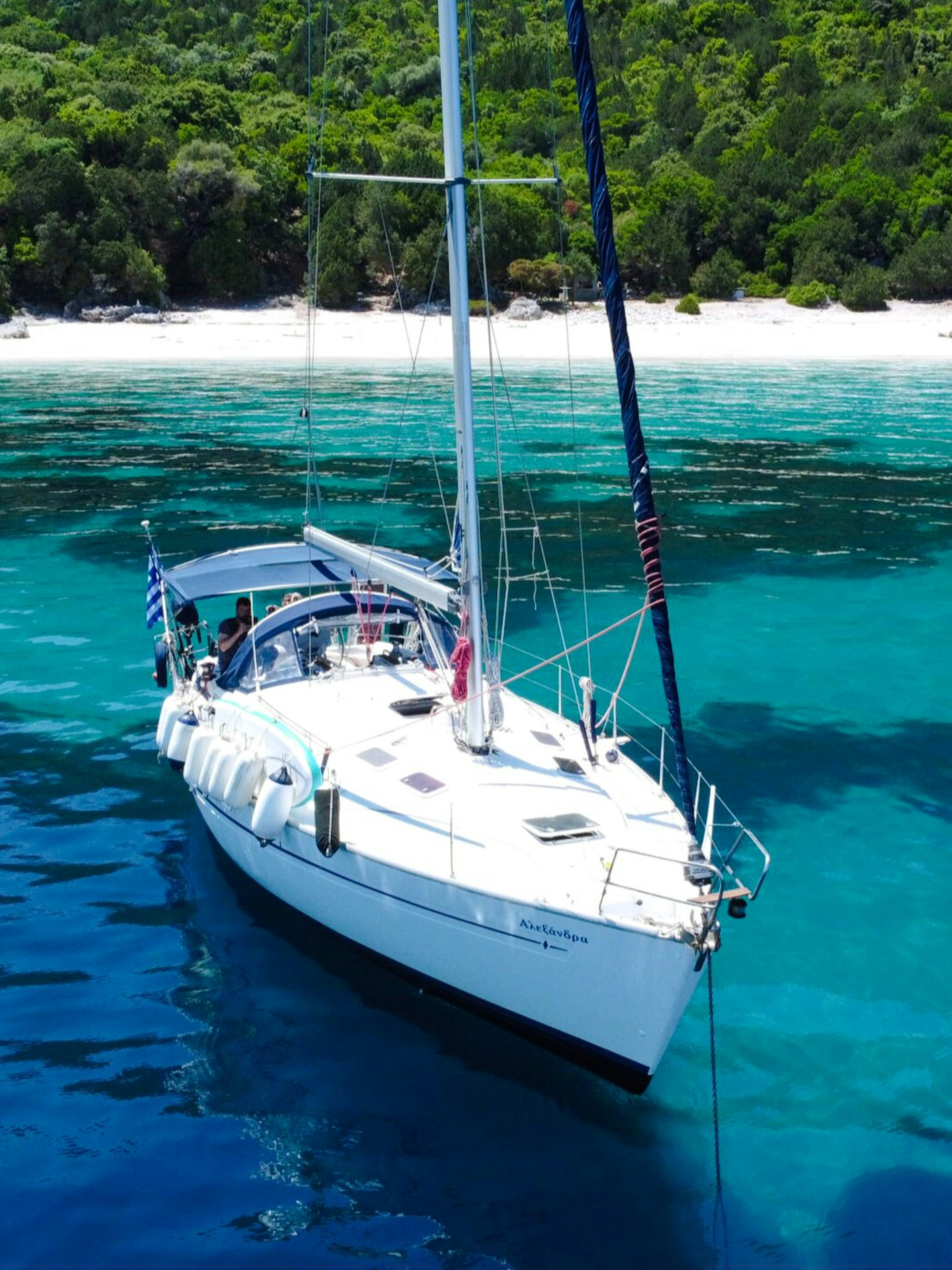 Sailing yacht on turquoise waters near a secluded beach in Kefalonia.