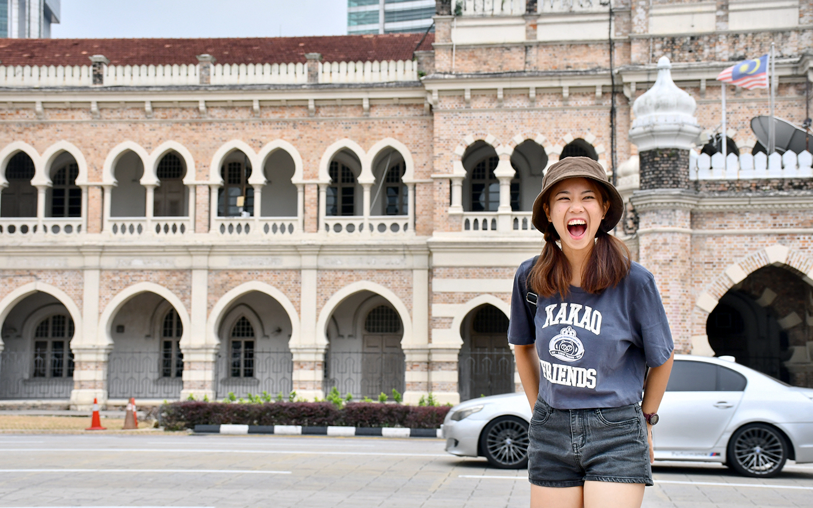 Tourist smiling in front of Sultan Abdul Samad Building, Kuala Lumpur.