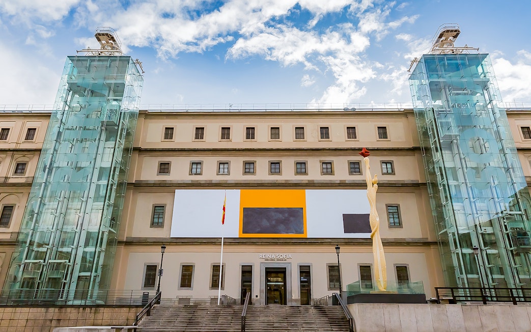 Reina Sofia Museum entrance in Madrid, Spain with modern art sculpture and glass elevators.