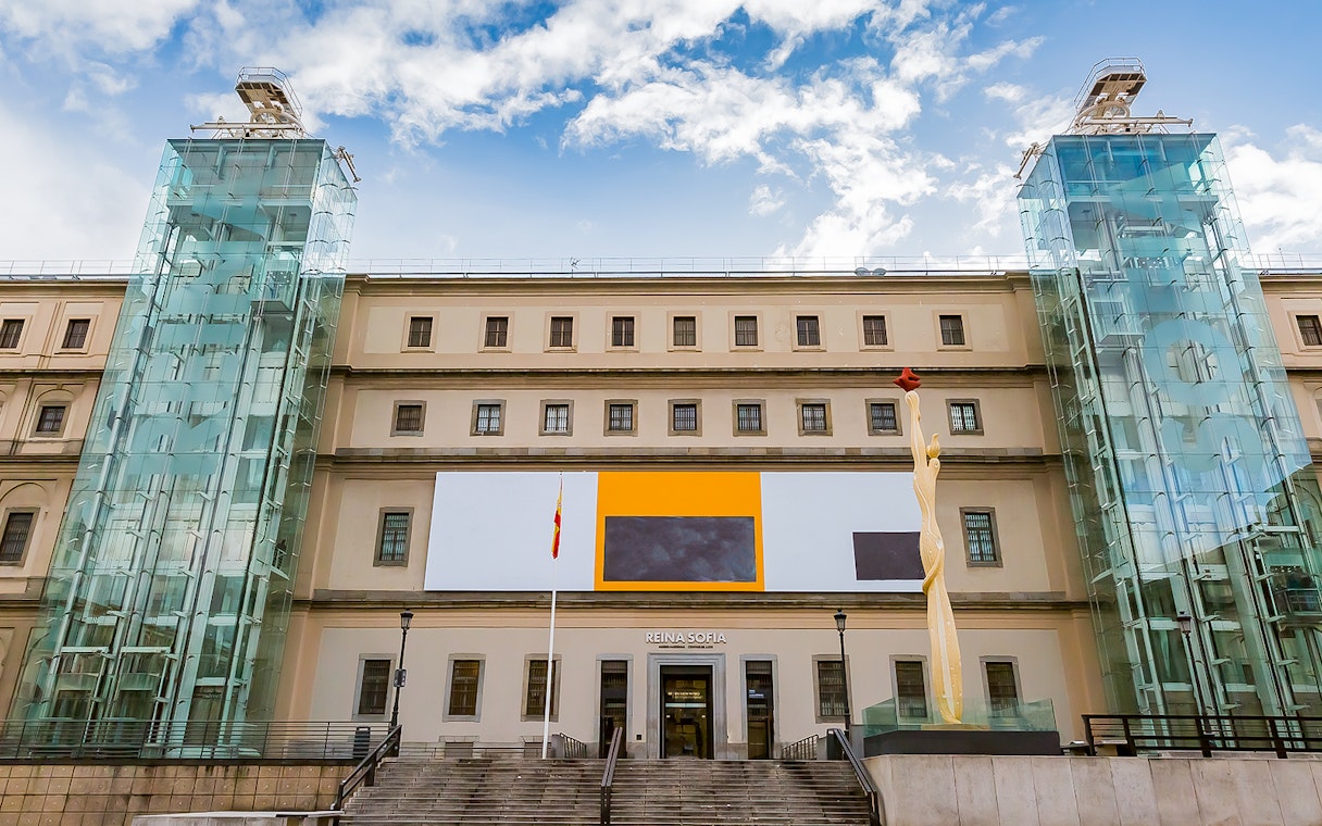 Reina Sofia Museum entrance in Madrid, Spain with modern art sculpture and glass elevators.