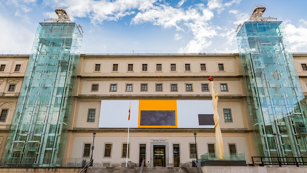 Reina Sofia Museum entrance in Madrid, Spain with modern art sculpture and glass elevators.