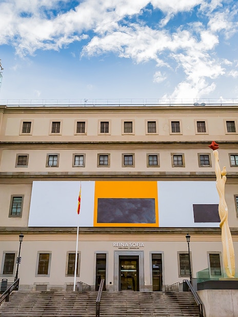 Reina Sofia Museum entrance in Madrid, Spain with modern art sculpture and glass elevators.