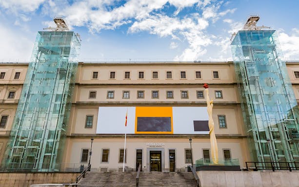 Reina Sofia Museum entrance in Madrid, Spain with modern art sculpture and glass elevators.