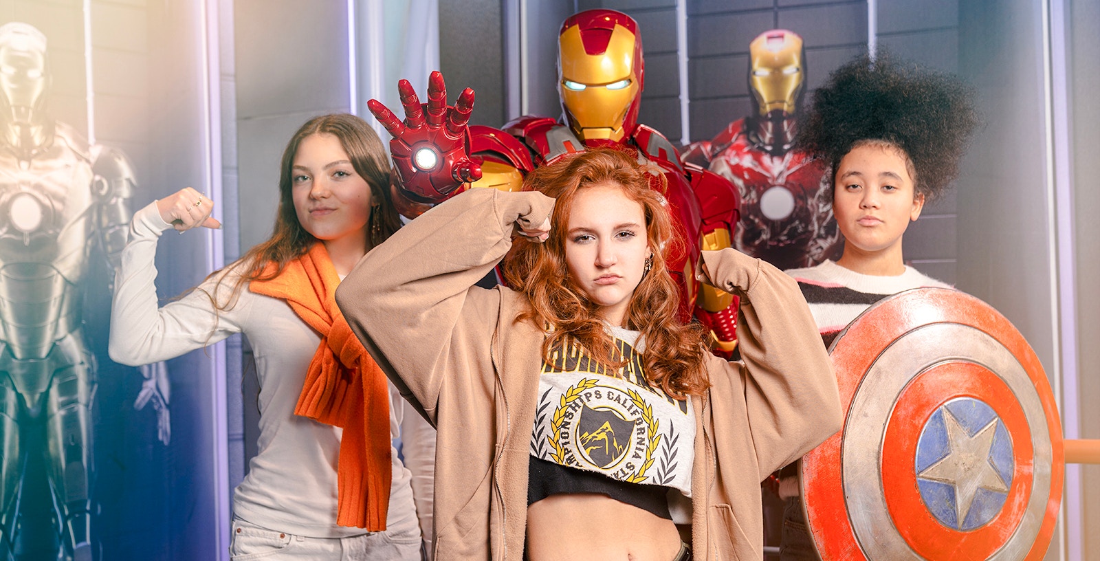 Visitors posing with Iron Man and Captain America's shield at Madame Tussauds Amsterdam.