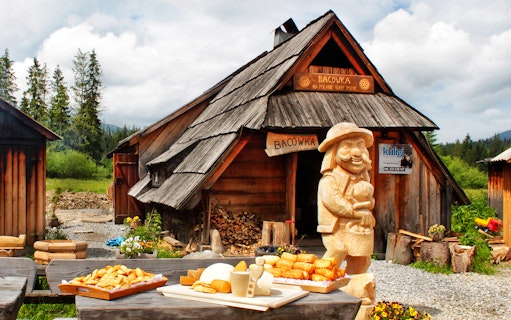 Oscypek cheese and local alcohol displayed at Bacówka in a rustic mountain setting.