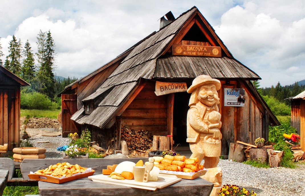 Zakopane Bacówka serving oscypek cheese and local alcohol with mountain backdrop.