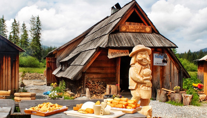 Zakopane Bacówka serving oscypek cheese and local alcohol with mountain backdrop.