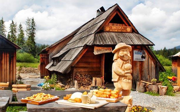 Oscypek cheese and local alcohol displayed at Bacówka in a rustic mountain setting.
