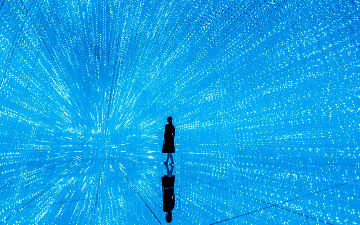 Person standing in immersive digital art installation at teamLab SuperNature Macau.