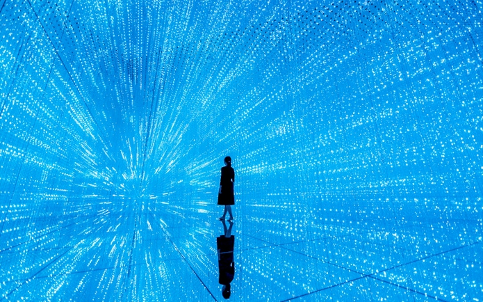 Person standing in immersive digital art installation at teamLab SuperNature Macau.