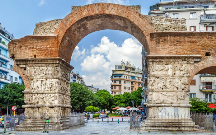 Arch of Galerius in Thessaloniki, Greece with detailed carvings and cityscape background.